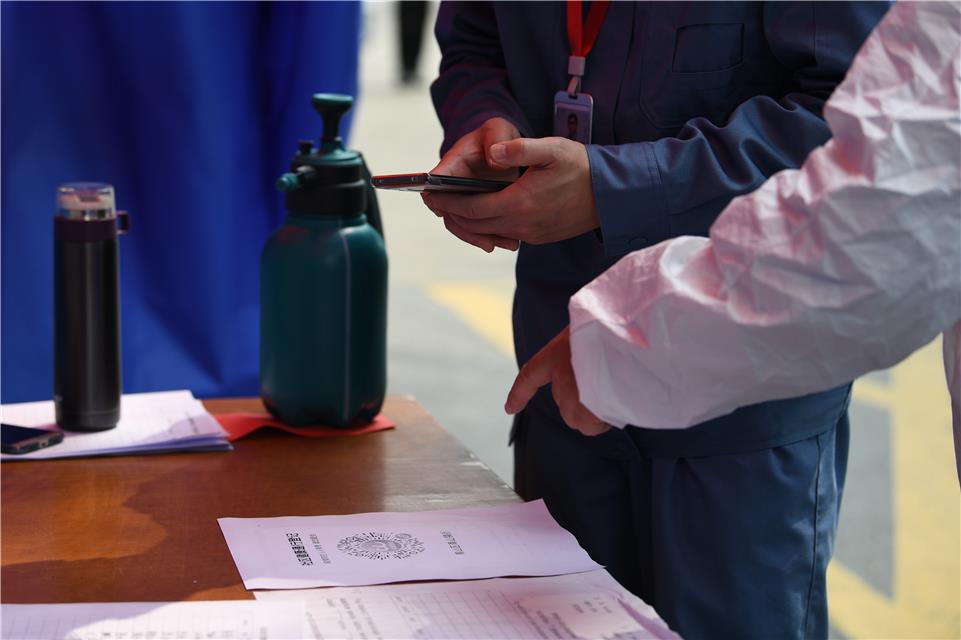  3月23日，武汉市青山区青山镇街石化社区，居民通过扫绿码进入小区。