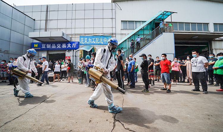 岳各庄批发市场，蓝天救援队正对市场进行消杀，商户和职工排队进行核酸检测。