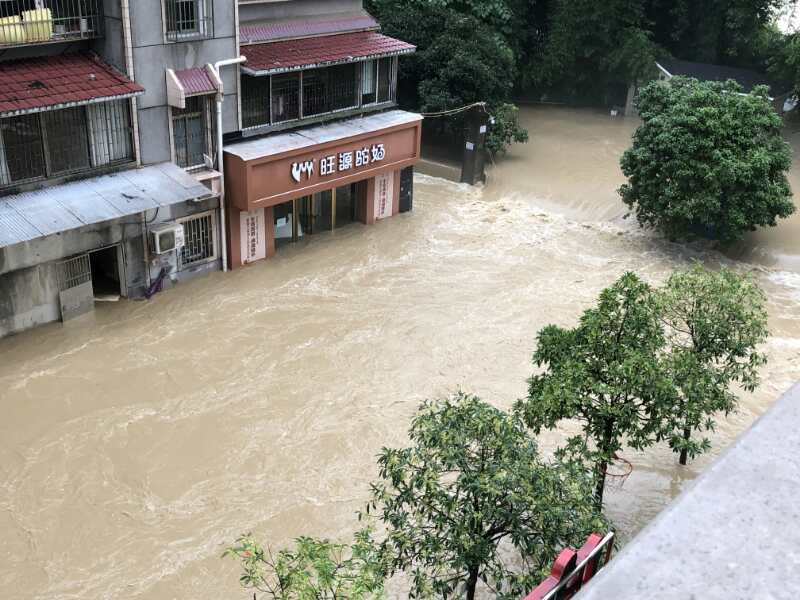 7月17日下午，清江河水漫过亲水走廊倒灌入城区，形成瀑帘，一楼商铺被淹。  受访者供图