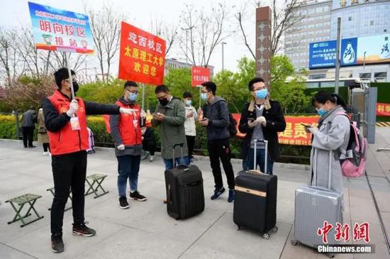 资料图：4月10日，山西太原火车站，高校返校学生在出站口接受体温检测。当日，山西省首批高校本硕博毕业年级开学复课。中新社记者 韦亮 摄